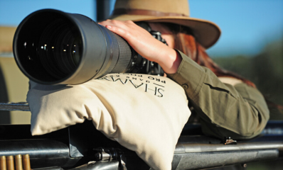 Guest rests on a pillow while focusing on a distant object with their camera.